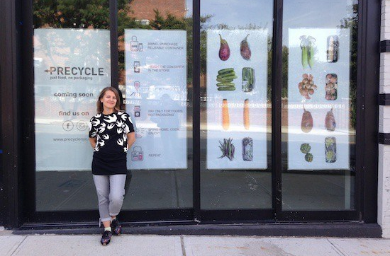 Woman standing in front of vegetable store